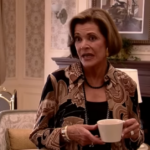 Lucille Bluth de la série Arrested Development. L’air dédaigneux, une tasse de café à la main.